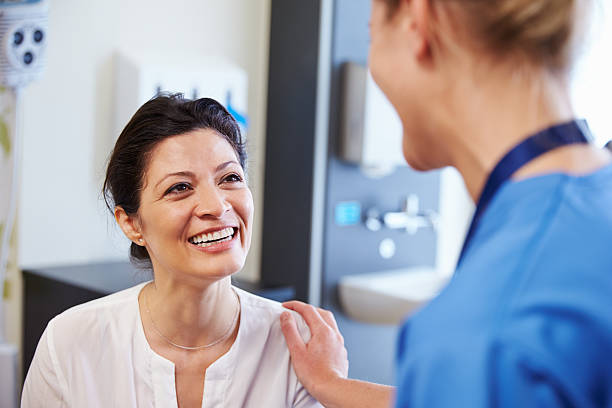 female patient being reassured by doctor in hospital room - smiling nurse bildbanksfoton och bilder