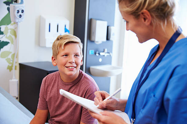 10 代の少年と医師が病院でのご宿泊 - scrubs expertise focus confidence ストックフォトと画像