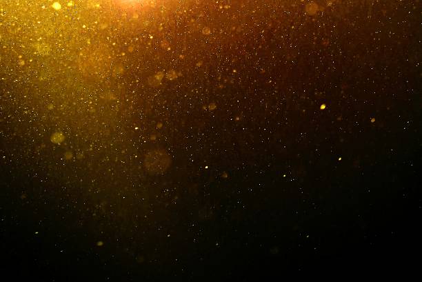 Abstract gold background with floating dust Abstract gold background with floating and reflecting dust light effect stock pictures, royalty-free photos & images