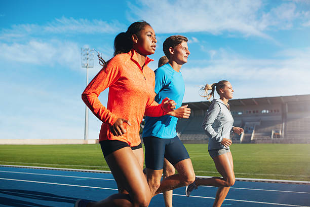 istock Runners running on race track in stadium 489302282