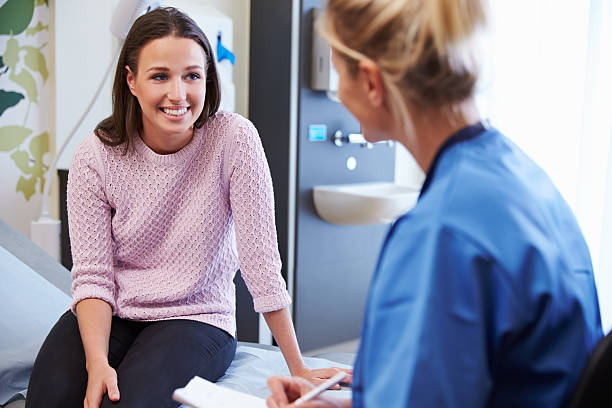 Female Patient And Nurse Have Consultation In Hospital Room Female Patient And Nurse Have Consultation In Hospital Room woman talking to doctor stock pictures, royalty-free photos & images