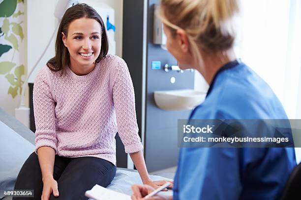 Female Patient And Nurse Have Consultation In Hospital Room Stock Photo - Download Image Now