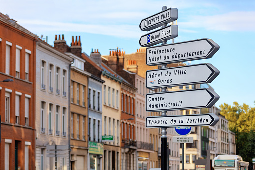 Lille, France - August 14, 2015: Street sign pointing to various tourist destinations and sights on old town background