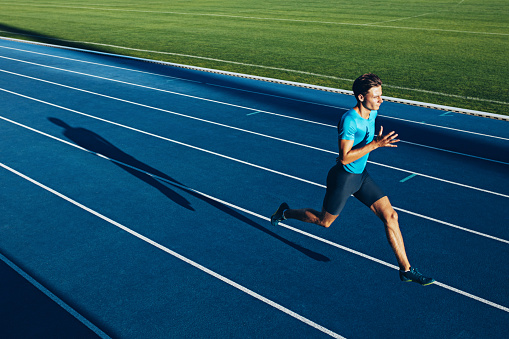 Shot of a young male athlete training on a race track. Sprinter running on athletics tracks.