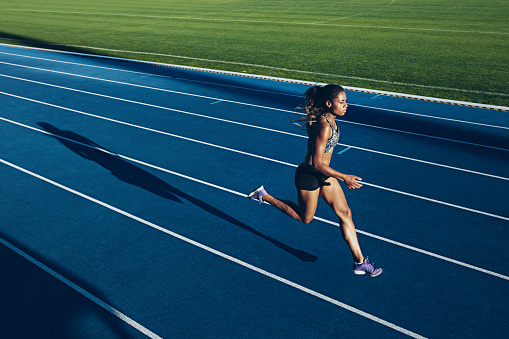 African mujer corriendo en la pista de carreras photo