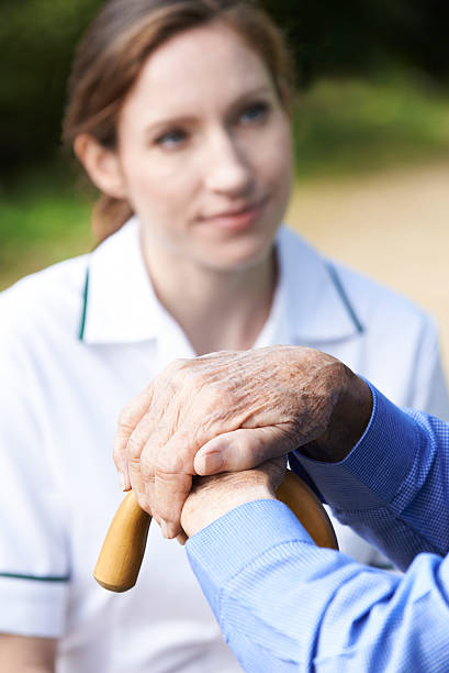 istock Senior Man's Hands On Walking Stick With Care Worker In 489309670