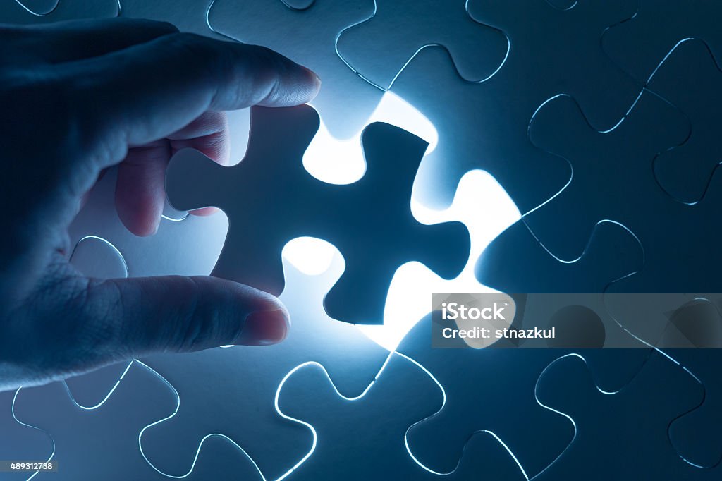 Hand insert jigsaw, conceptual image of business strategy Jigsaw Puzzle Stock Photo