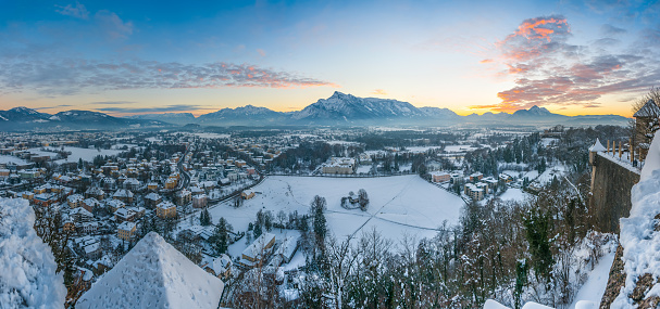 Beautiful view of the historic city of Salzburg and mountains from top of Festung Hohensalzburg in winter at sunset, Salzburger Land, Austria