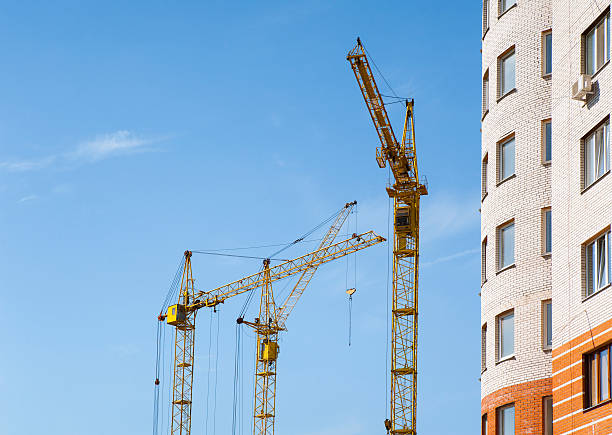 istock Yellow tower cranes and new residential building 489316302