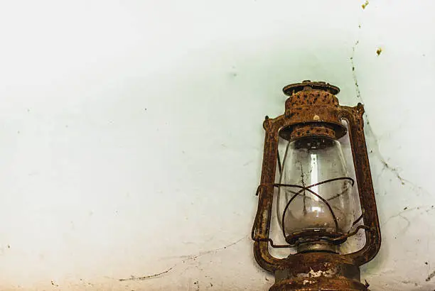 Old kerosene lamp with cobwebs and unusable
