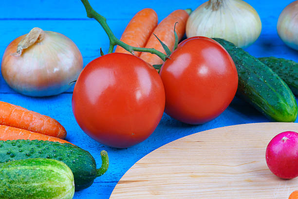 istock Fresh vegetables and cutting board on wooden table 489336788