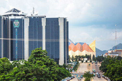 Abuja, Nigeria - September 4, 2015: Central Bank of Nigeria headquarters building seen from the street, National Ecumenical Centre in background.