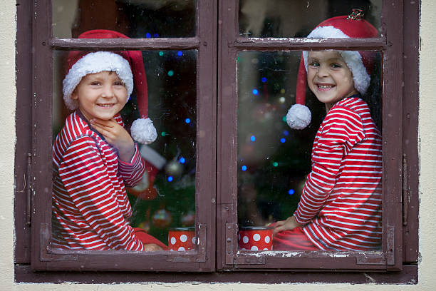 istock Two cute boys, brothers, looking through window, waiting Santa 489338468
