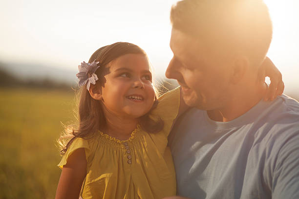 istock Father and daughter on meadow at sunset 489343314