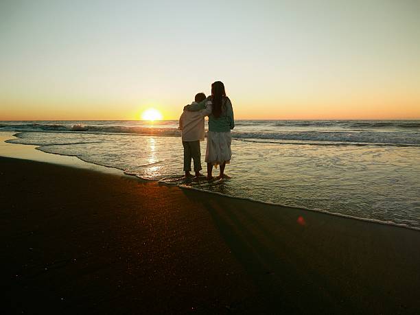 istock Boy And Girl Playing Ocean Sunrise 489343446