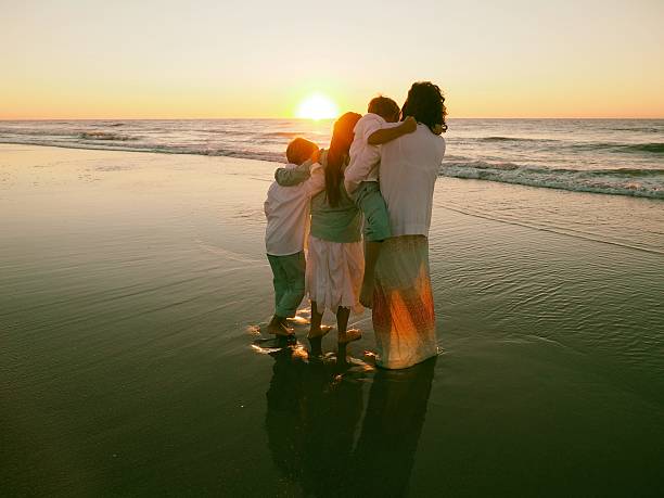 istock Mother and Children On Beach At Sunrise 489343600