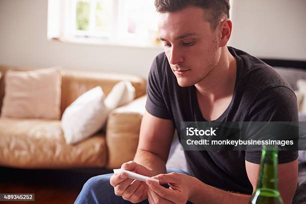 Young Man Smoking Marijuana At Home Stock Photo - Download Image Now - 20-29 Years, 2015, Addiction