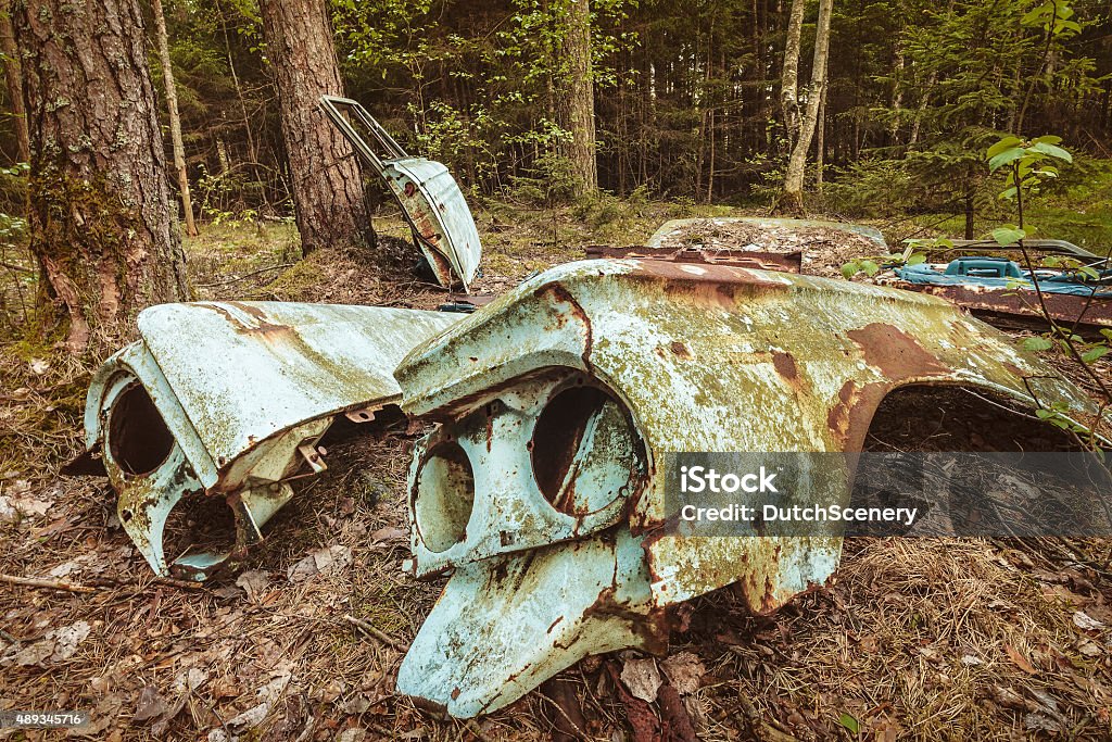 Old rusted scrap car in a forest Parts of an old rusted and weathered scrap car in a forest 2015 Stock Photo