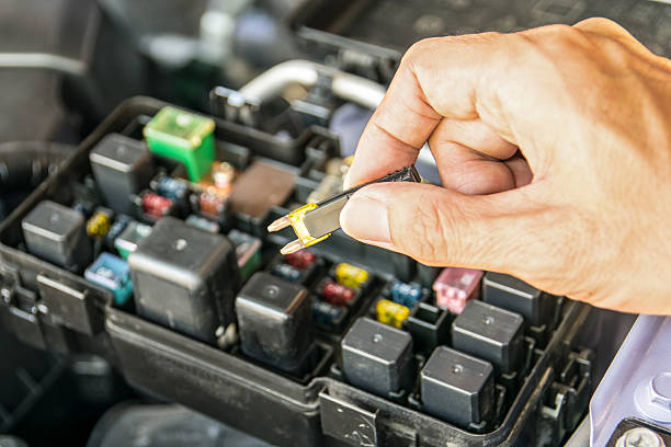 Auto mechanic checking a car fuse
