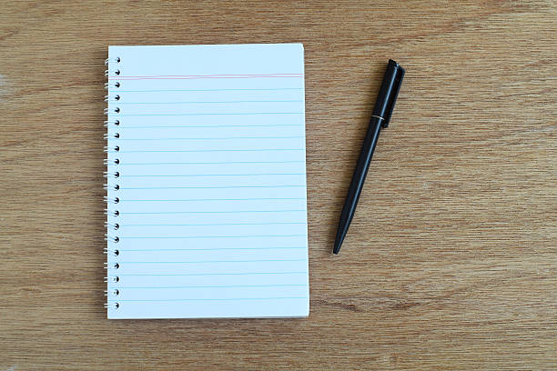 istock White paper with a pen on top, selective focus 489349988