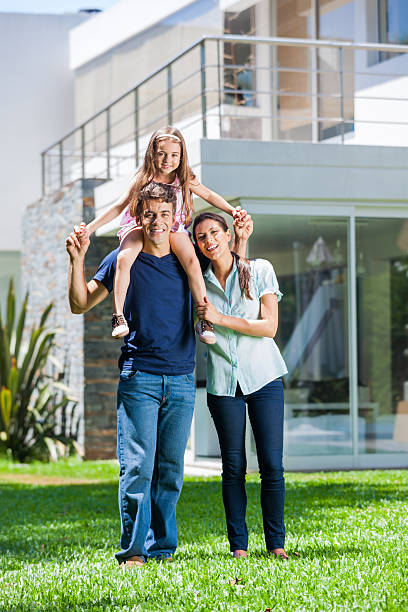 istock Family with daughter in front house 489356073