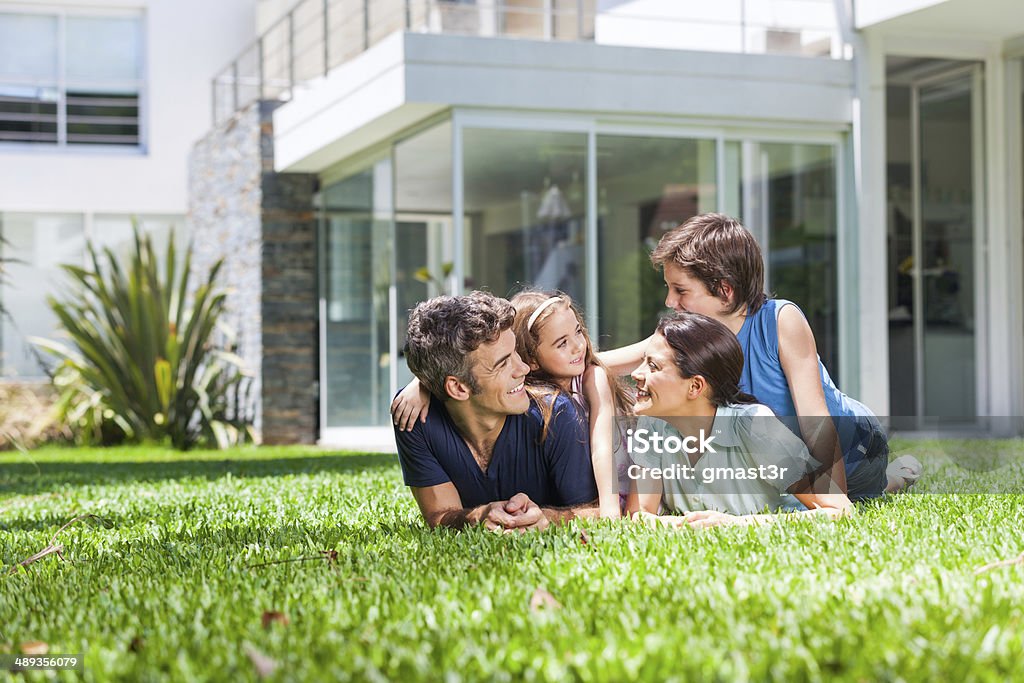 Famiglia con due bambini Sdraiato su un erba - Foto stock royalty-free di Famiglia