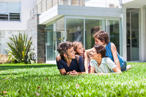 famiglia con due bambini sdraiato su un erba - house garden foto e immagini stock