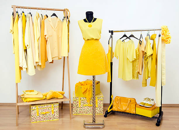 Wardrobe with all shades of yellow clothes, shoes and accessories. stock photo