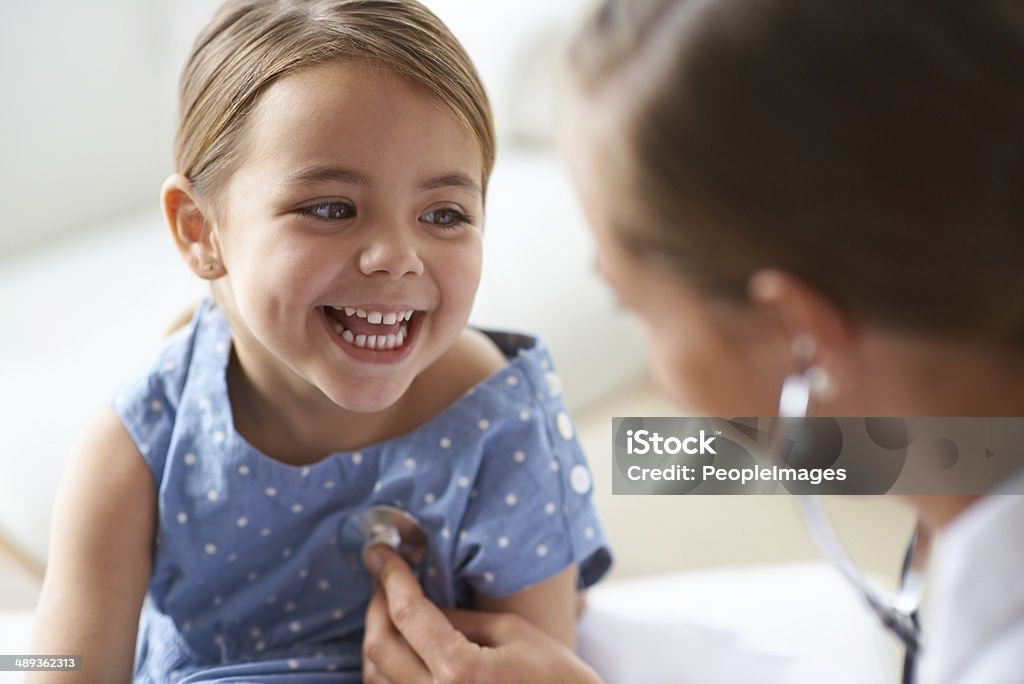 That tickles! Cropped shot of an adorable young girl with her pediatrician Child Stock Photo