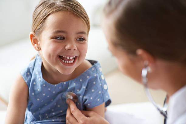 That tickles! Cropped shot of an adorable young girl with her pediatrician girl patient stock pictures, royalty-free photos & images