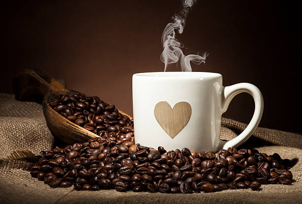 istock White cup with heart and coffee beans on dark background 489377032