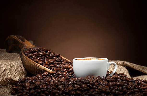 istock White cup with coffee beans on dark background 489377118
