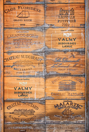 Saint Emilion, France - August 19, 2015: Collection of old famous Bordeaux wine wood boxes used as decoration on a wall.