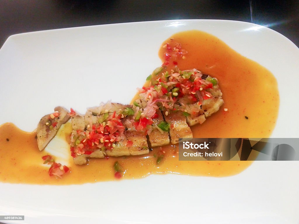 Prepaired pork belly Japanese cuisine - pork belly in sauce with vegetables, cut in pieces on white plate.  2015 Stock Photo