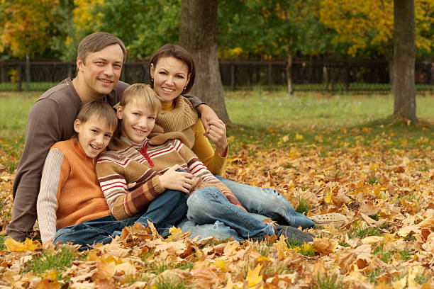 istock family sitting in a autumn park 489382124