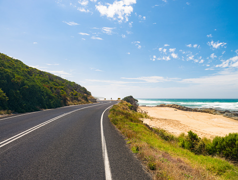 A sandy beach next to a section of the Great Ocean Road, near the town of Apollo Bay in Victoria State, Australia.