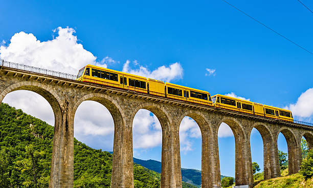The Yellow Train (Train Jaune) on Sejourne bridge The Yellow Train (Train Jaune) on Sejourne bridge - France, Pyrenees-Orientales hanging stone stock pictures, royalty-free photos & images