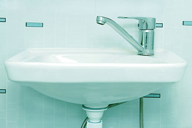 istock Wash sink with tap in a bathroom.Neon toned image. 489386184
