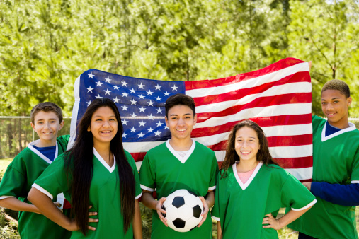 Team of teenage soccer players with American flag in background.  Go team USA!  
