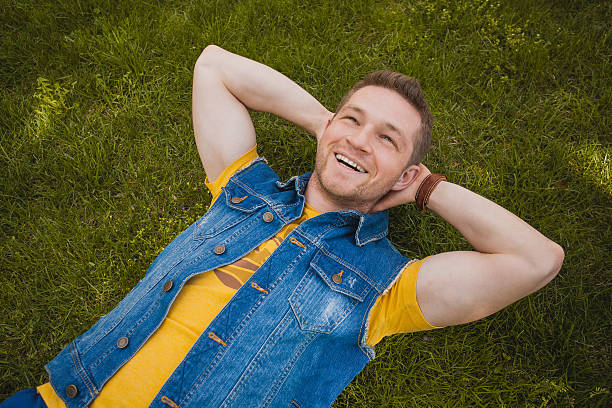 istock young man in the park lying on grass 489427565