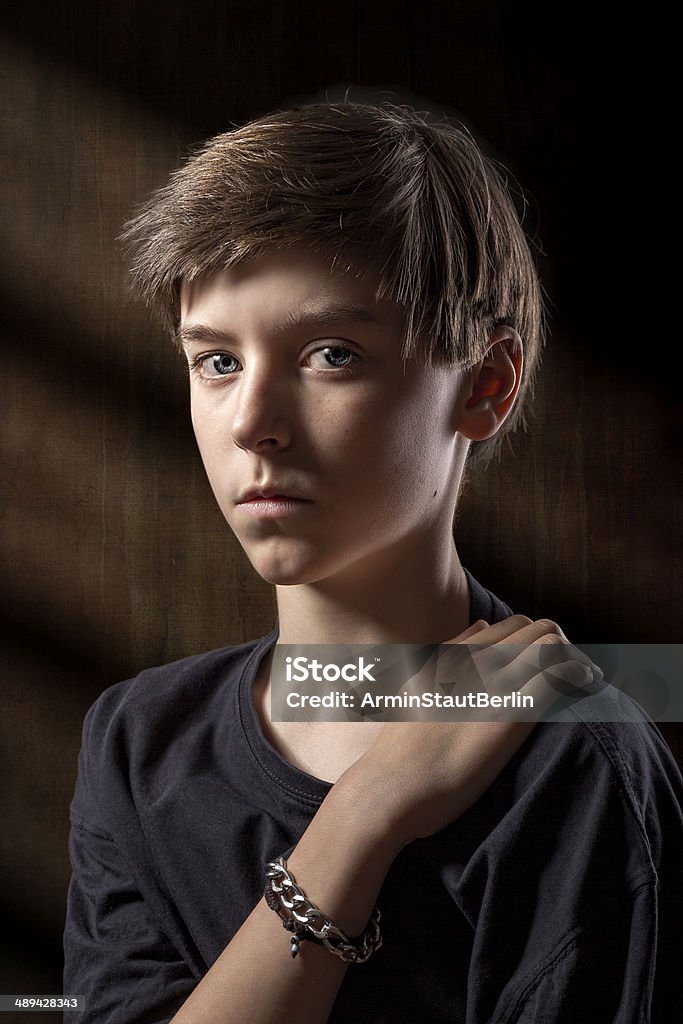 portrait of a male teenager with brown background portrait of a male teenager with brown background and light stripes. Depression - Sadness Stock Photo