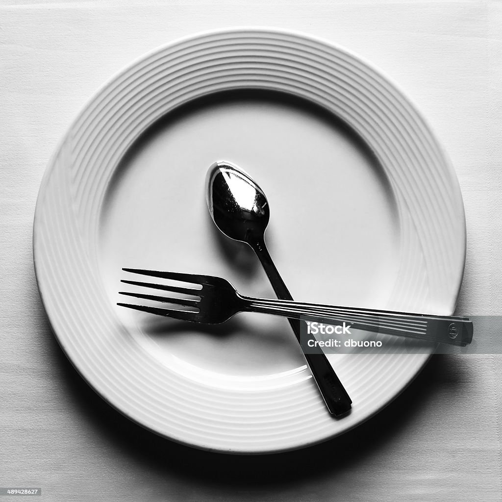 Plate with fork and spoon White plate with fork and spoon Fork Stock Photo