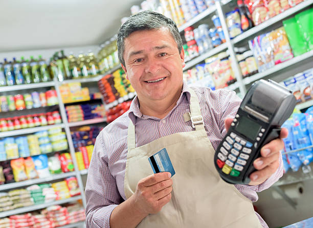 istock Shopkeeper holding a credit card machine 489431906