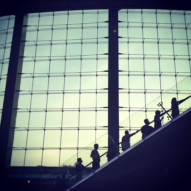 istock silhouettes man going up by escalator airport 489433755