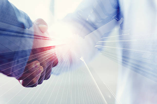 istock Close up of two people shaking hands with city 489435548