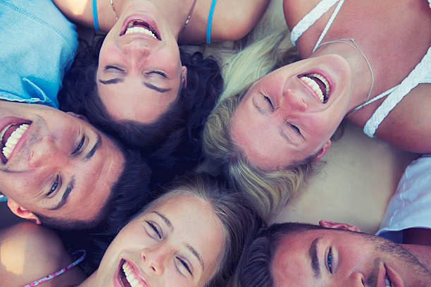 istock Group of young people lying down in a circle. 489437470