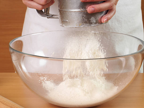 istock Sifting flour into bowl. Making Chocolate Layer Cake with Cream 489437512