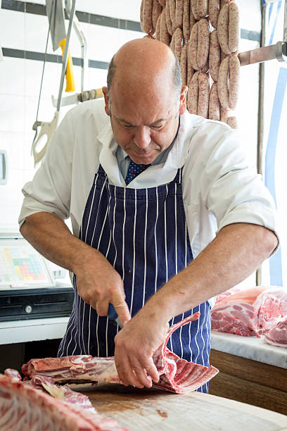istock Butcher trimming joint of meat with a sharp knife 489437724