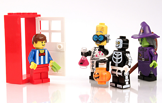 Colorado, USA - September 15, 2015: Studio shot of Lego minifigures dressed up for Halloween and representing trick or treating scene.