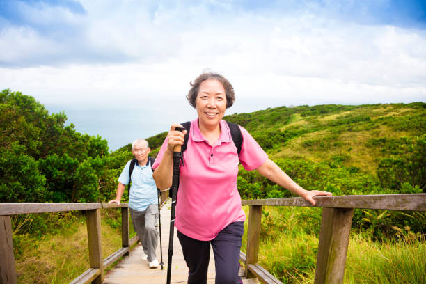 feliz pareja senior caminando en la montaña - couple mature adult action walking fotografías e imágenes de stock